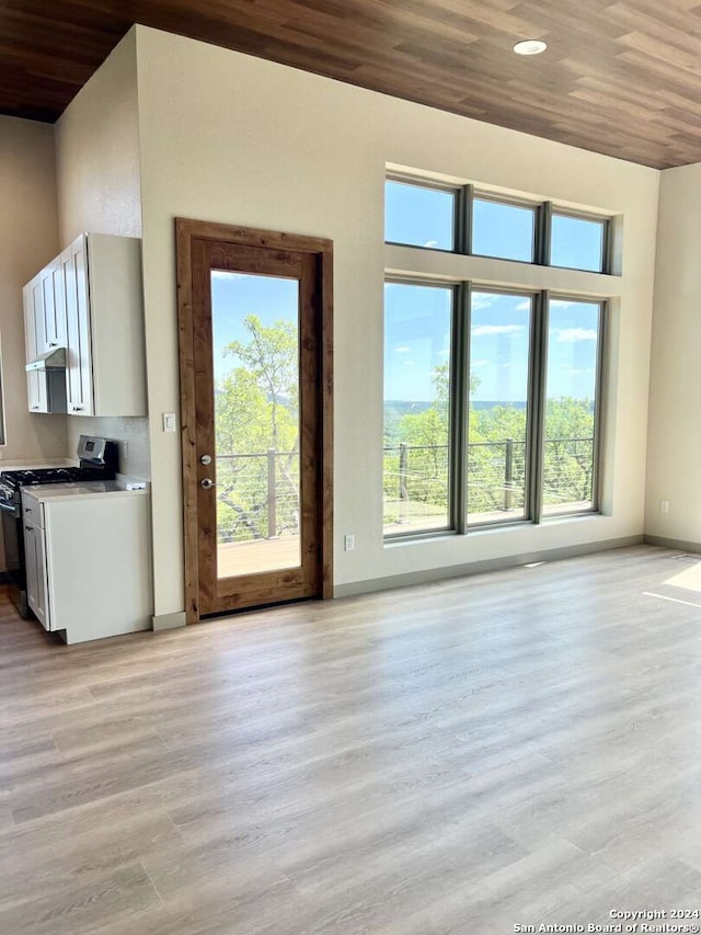 unfurnished living room with light wood-type flooring and wooden ceiling