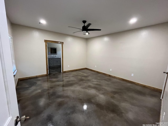 unfurnished room featuring baseboards, a ceiling fan, and finished concrete floors