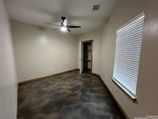 unfurnished bedroom featuring concrete flooring, visible vents, baseboards, and a ceiling fan