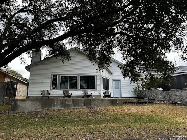 rear view of property featuring a yard