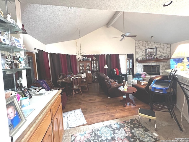 office space with hardwood / wood-style floors, a textured ceiling, vaulted ceiling with beams, ceiling fan with notable chandelier, and a fireplace