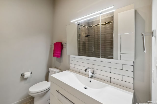 bathroom with vanity, tasteful backsplash, toilet, and walk in shower