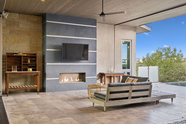 view of patio featuring an outdoor living space with a fireplace and ceiling fan