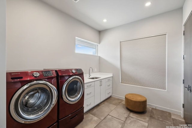 laundry area featuring sink, light tile patterned flooring, washer and dryer, and cabinets