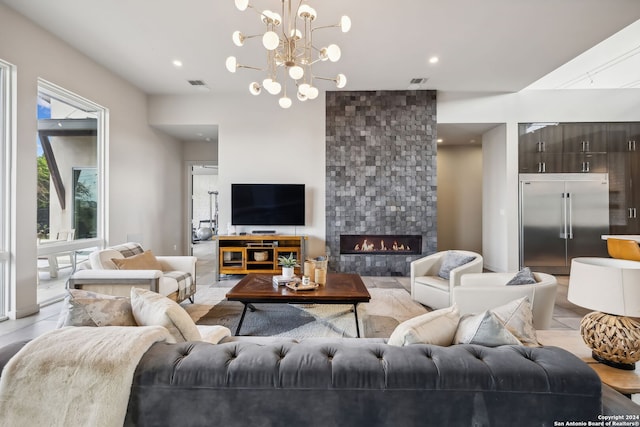 living room featuring a chandelier and a fireplace