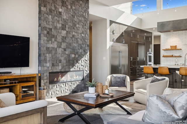 living room featuring a high ceiling and a fireplace