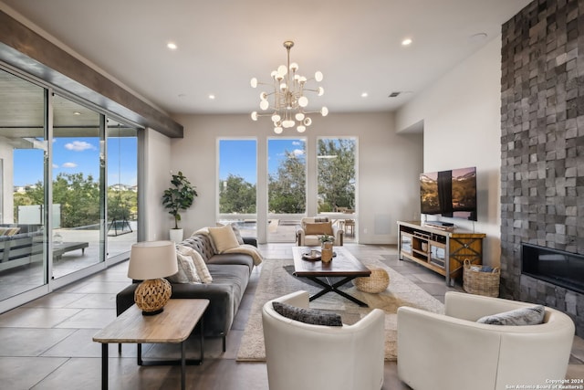 tiled living room featuring an inviting chandelier and a large fireplace