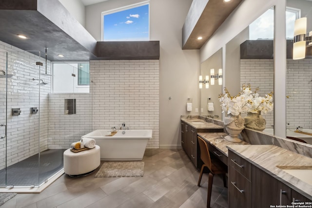 bathroom featuring vanity and independent shower and bath