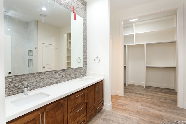 bathroom with vanity, hardwood / wood-style floors, and tasteful backsplash