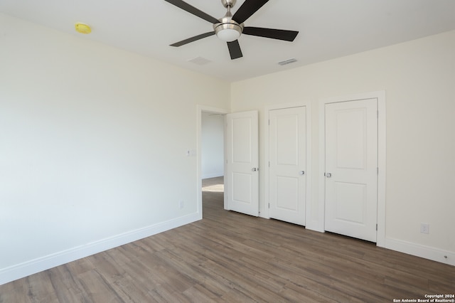 unfurnished bedroom featuring dark hardwood / wood-style floors and ceiling fan