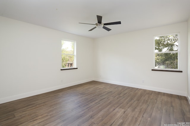 unfurnished room with ceiling fan, a healthy amount of sunlight, and dark hardwood / wood-style floors