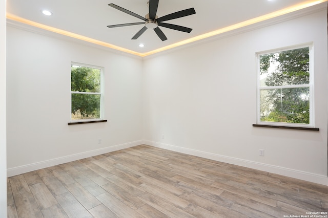 empty room with ceiling fan, crown molding, and light wood-type flooring