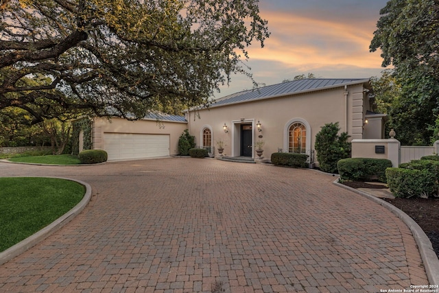 mediterranean / spanish-style house with a garage