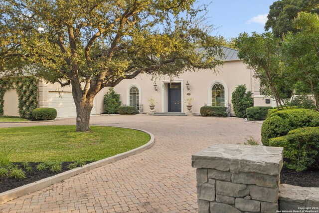 800 Ivy Ln, Terrell Hills, TX 78209 - view of front of house with curved driveway, stucco siding, a standing seam roof, and metal roof