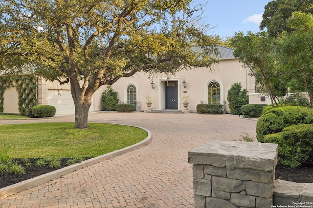 view of front of home featuring a garage and a front lawn