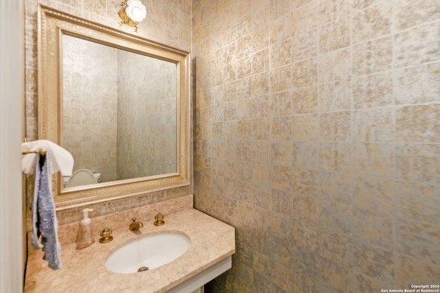 bathroom featuring tile walls and sink