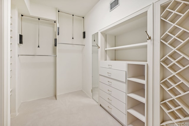 walk in closet featuring light carpet