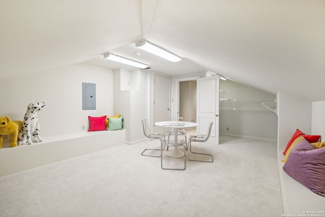 dining space with electric panel, vaulted ceiling, and light carpet