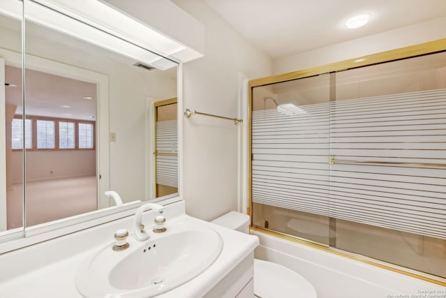 full bathroom featuring toilet, vanity, and shower / bath combination with glass door