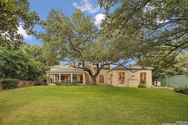 rear view of property featuring a lawn