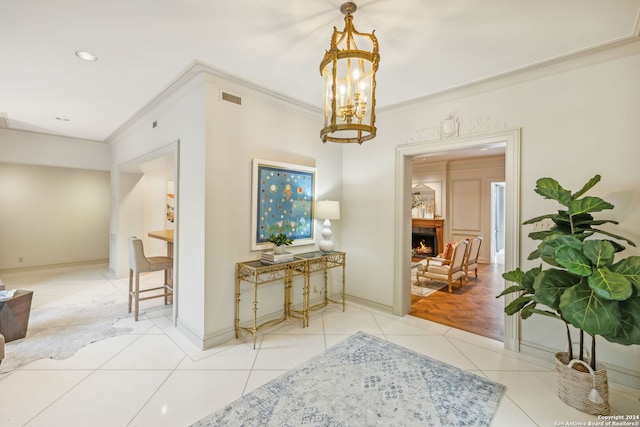 corridor with a chandelier, light tile patterned floors, and crown molding