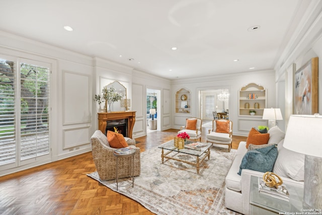 living room with built in features, parquet floors, ornamental molding, and a healthy amount of sunlight