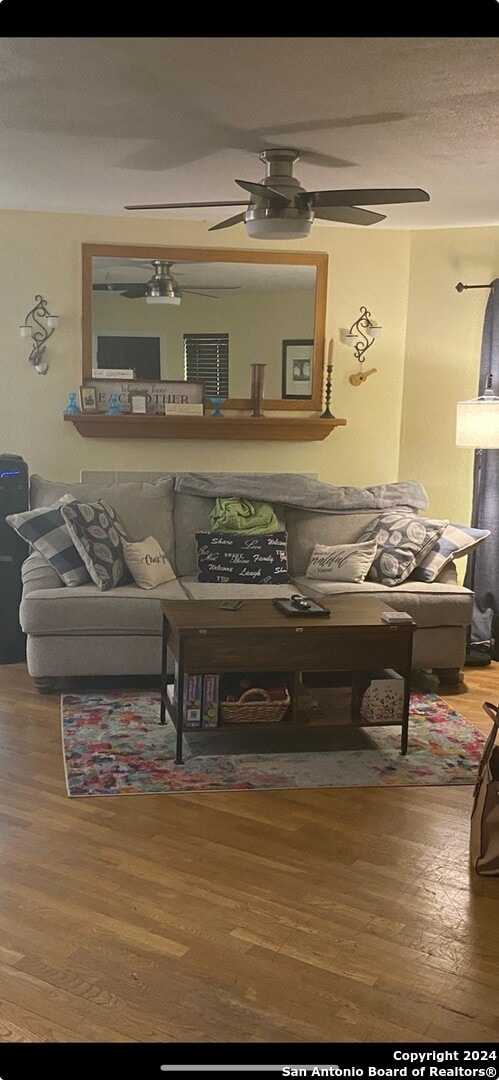 living room featuring hardwood / wood-style floors and ceiling fan