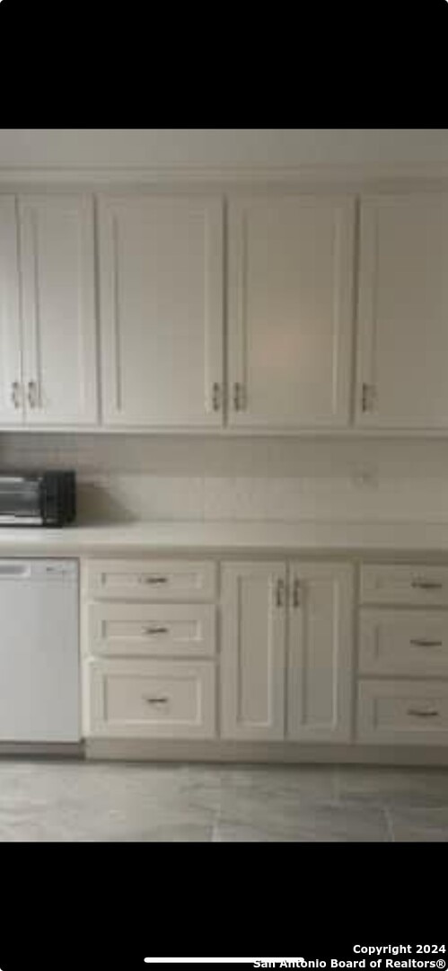 kitchen with dishwasher and white cabinetry