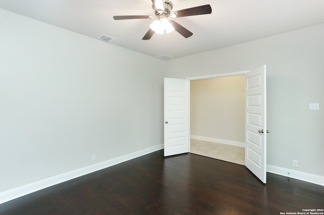 unfurnished bedroom with ceiling fan and dark hardwood / wood-style floors