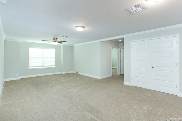 spare room with ornamental molding, light carpet, and ceiling fan