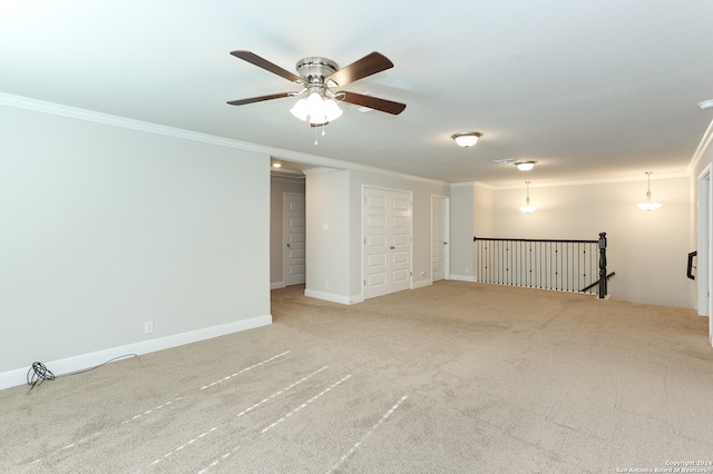 carpeted spare room featuring ceiling fan and crown molding