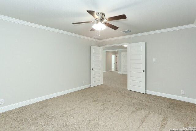 carpeted spare room featuring ceiling fan and ornamental molding