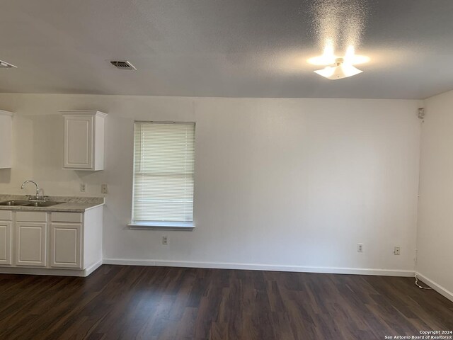 9058 Boston Hbr, San Antonio, TX 78242 - unfurnished dining area with a sink, dark wood-type flooring, and baseboards