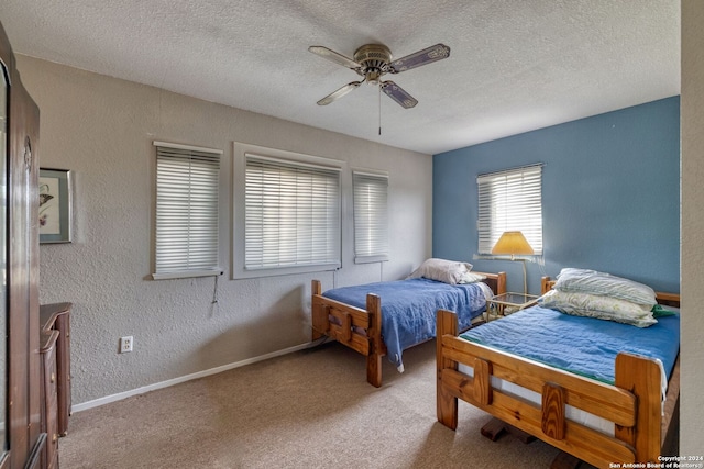 carpeted bedroom with ceiling fan and a textured ceiling