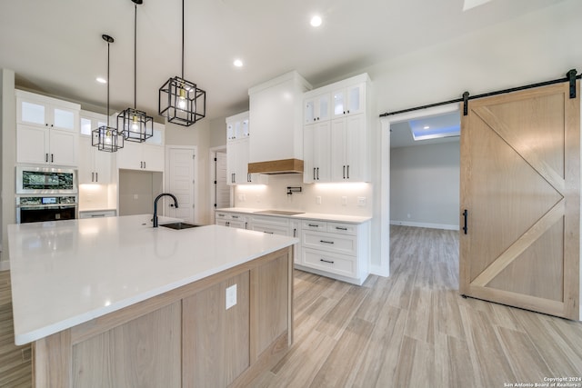 kitchen with a large island, white cabinetry, sink, and stainless steel appliances