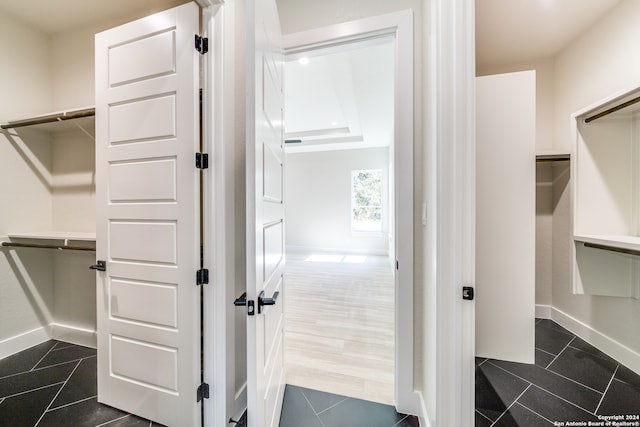 walk in closet with dark tile patterned flooring