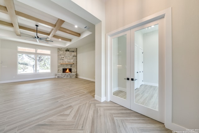 unfurnished living room with french doors, beam ceiling, coffered ceiling, and a fireplace