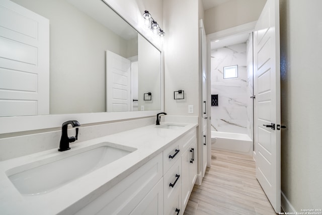 full bathroom with vanity, toilet, wood-type flooring, and tiled shower / bath