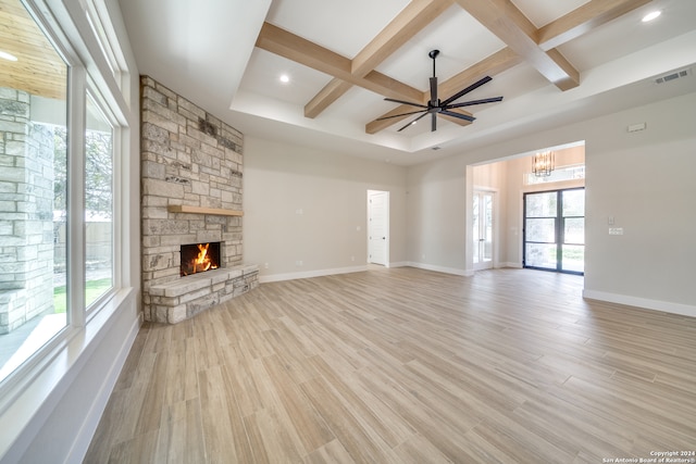 unfurnished living room featuring coffered ceiling, a wealth of natural light, and light wood-type flooring