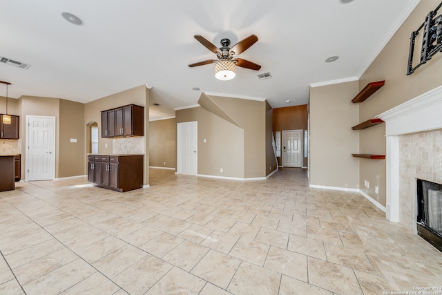 unfurnished living room featuring ceiling fan, ornamental molding, and a fireplace