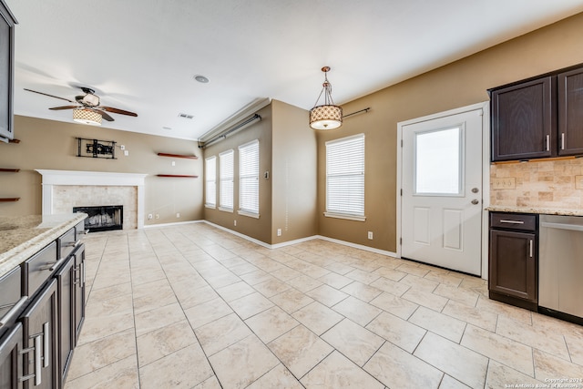 interior space with a tiled fireplace and ceiling fan