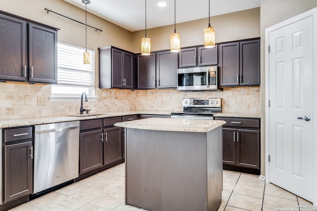 kitchen with appliances with stainless steel finishes, dark brown cabinets, a center island, and hanging light fixtures