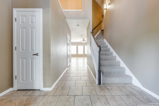 stairs featuring ceiling fan