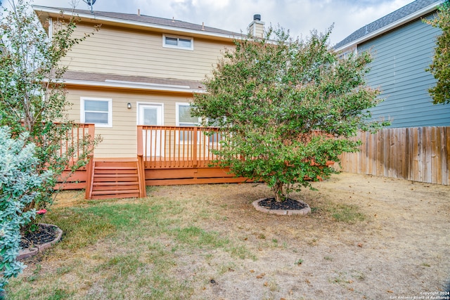 rear view of house featuring a yard and a deck