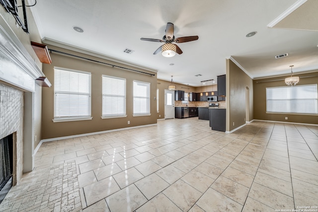 unfurnished living room featuring ornamental molding, light tile patterned floors, plenty of natural light, and ceiling fan with notable chandelier