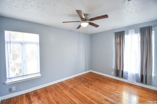 empty room with hardwood / wood-style floors, a textured ceiling, and ceiling fan