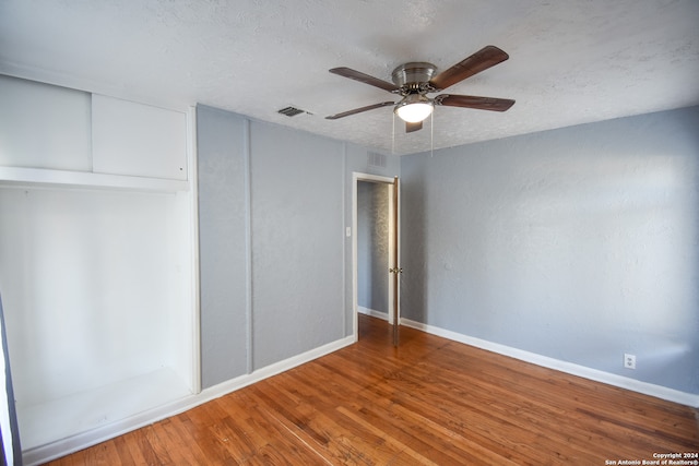 unfurnished bedroom with hardwood / wood-style floors, a textured ceiling, and ceiling fan