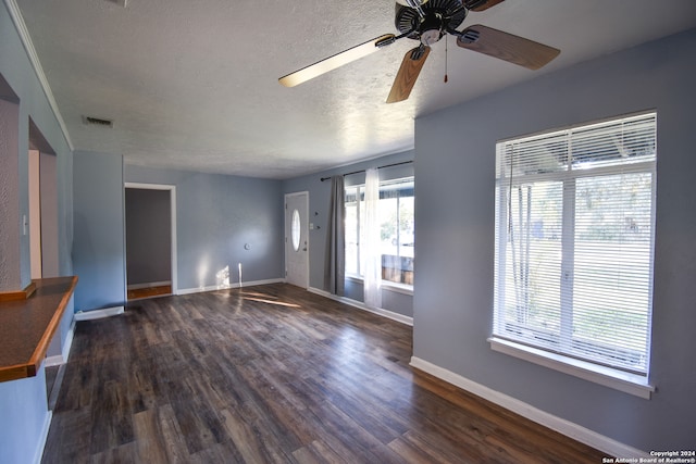 unfurnished living room featuring dark wood-type flooring, a textured ceiling, and ceiling fan