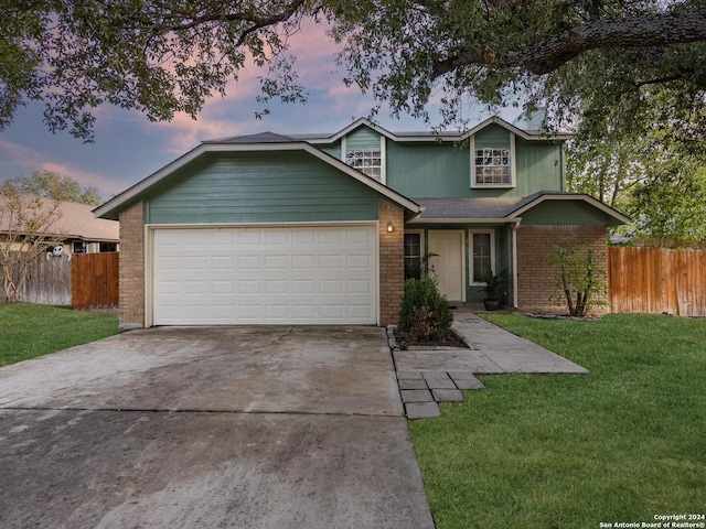 front of property featuring a garage and a lawn