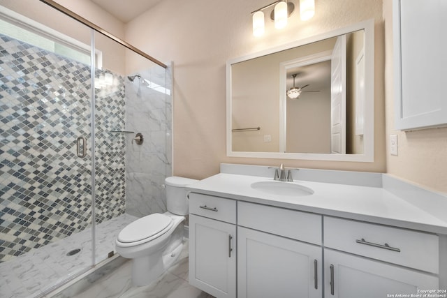 bathroom featuring a shower with door, toilet, ceiling fan, and vanity